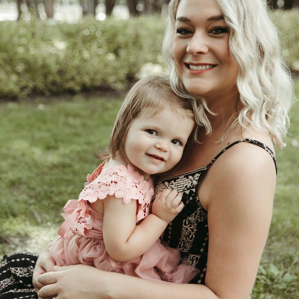 Samantha holding her daughter Ellington outdoors